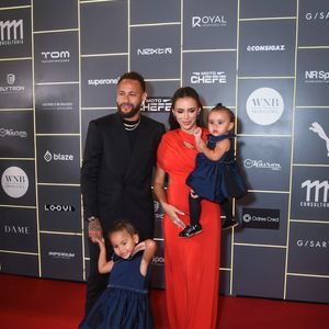 Bruna Biancardi e Neymar posam com as filhas em evento beneficente