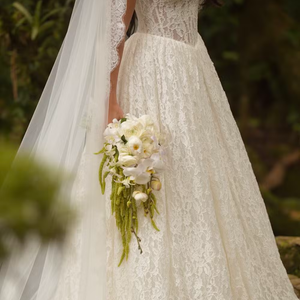 O vestido de noiva de Isabella Arantes combinou renda off-white, decote ombro a ombro, mangas longas e mantilha para o casamento com Gabriel Medina