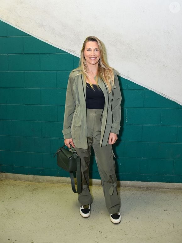 Anne Lottermann surgiu em uma proposta utilitária contemporânea com conjunto em tom verde-oliva. A composição reuniu parka leve com bolsos frontais e calça solta com tiras ajustáveis na barra sobre top preto básico