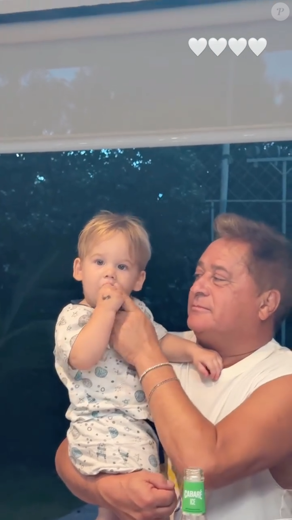 Leonardo coloca o dedo no gargalo da bebida e, em seguida, leva o dedo no canto da boca do neto