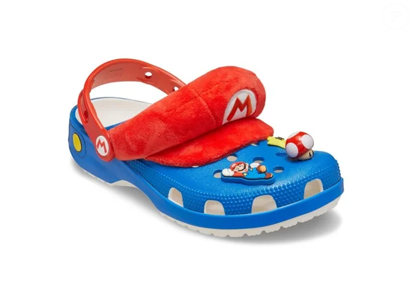 O modelo inspirado em Super Mario chega na cor azul e ganha detalhes estampados dos botões amarelos do macacão do personagem, além do tradicional "M" de Mario no rebite, reforçando a identidade visual da sandália