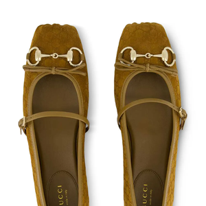 Produzida na Itália, a sapatilha apresenta acabamento em camurça em tom marrom mel, também conhecido como caramelo, o que garante uma aparência mais suave e menos formal do que o couro tradicional