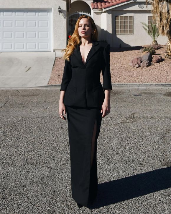 Carol Biazin escolheu a sofisticação minimalista e acertou em cheio! Seu conjunto preto de alfaiataria reinterpretada apresenta um blazer acinturado, decote profundo e ombros levemente marcados, combinados a uma saia longa e reta com fenda latera