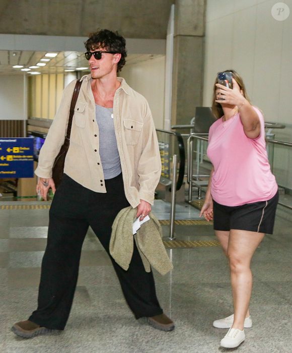 Shawn Mendes desembarca com look neutro e bolsa de couro marrom