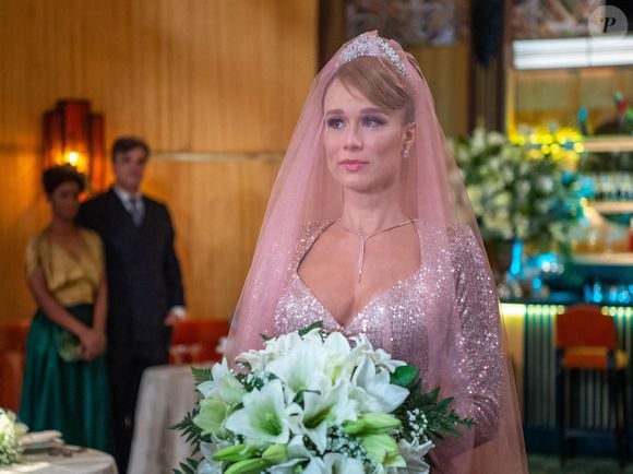 Para as noivas que não se identificam com o vestido branco tradicional, o look de Mariana Ximenes em 'Amor Perfeito 'oferece uma alternativa cheia de personalidade. O vestido rosa brilhante usado por Gilda no casamento com Orlando, personagem de Diogo Almeida, foi combinado com um véu longo da mesma cor. A proposta inspira quem deseja apostar em tons rosados para criar um visual romântico sem seguir as convenções