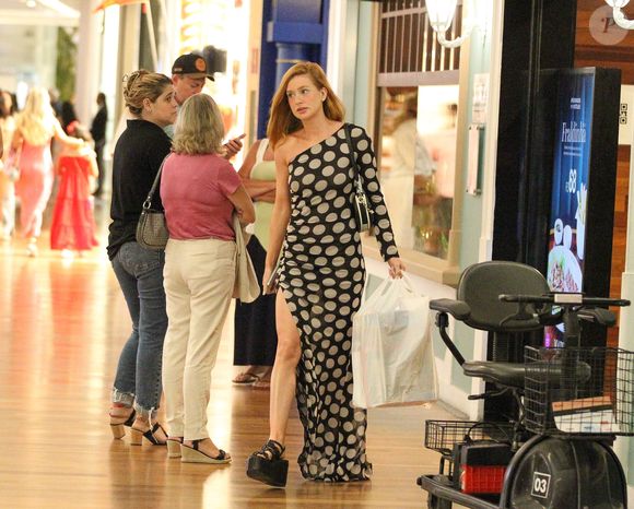 Para o passeio casual, Marina Ruy Barbosa escolheu um vestido preto com bolinhas cinzas com uma fenda até a altura da coxa