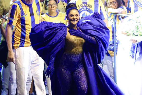 Mileide Mihaile surgiu ainda com uma capa com mangas bem volumosas em coroação como rainha de bateria da Unidos da Tijuca para o carnaval 2026