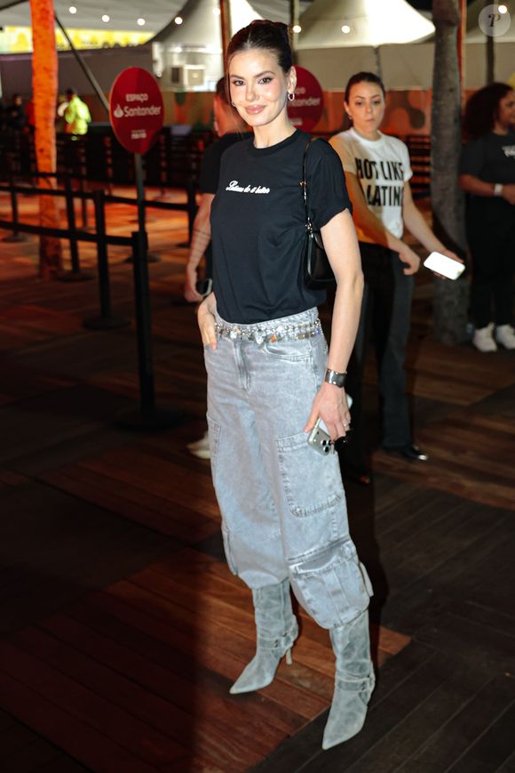 Camila Queiroz esbanjou beleza com uma camiseta preta simples e calça wide leg por dentro de uma bota de cano médio