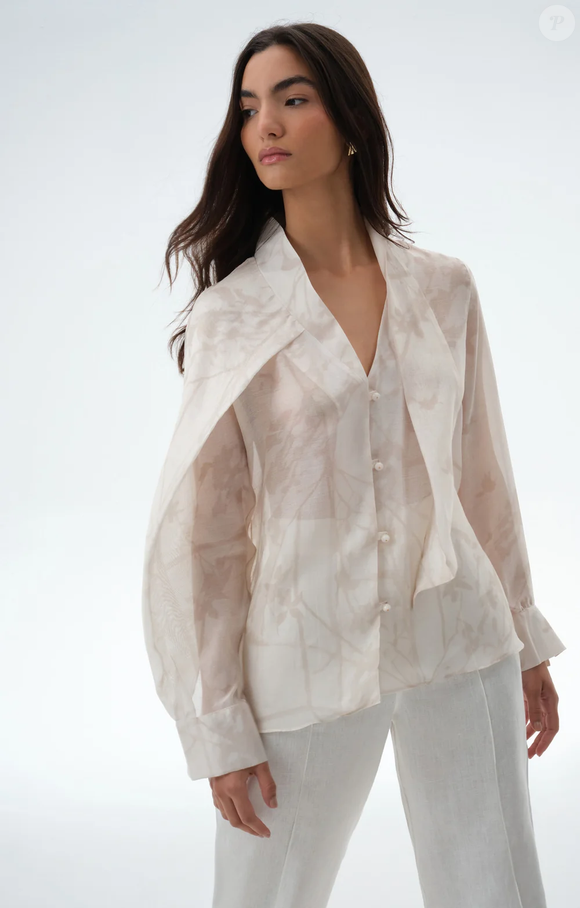 A Camisa Otilia, da Aleha, combina modal e seda com estampa exclusiva e faixas versáteis na gola, criando uma releitura sofisticada da clássica camisa branca de Carolina Herrera
