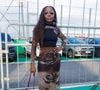 Para quem gosta de uma produção mais ousada, a inspiração é o look com tule e sobreposição. A composição da atriz Clara Moneke, reúne saia midi transparente com estampa artística e mística, usada sobre um short de alta compressão estilo biker, além de top assimétrico e mangas removíveis em tule