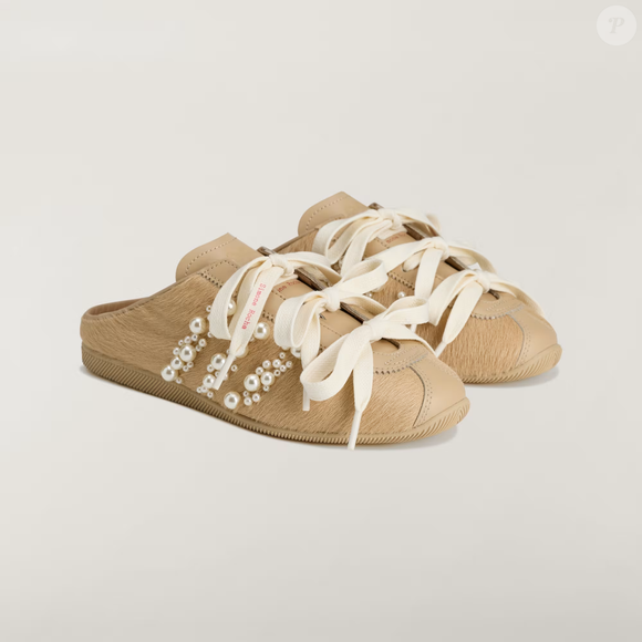 Na cor 'espuma de ostra', o Slip-on Simone Rocha Japan combina aplicações de pérolas na lateral, laços de fita de cetim e cabedal texturizado
