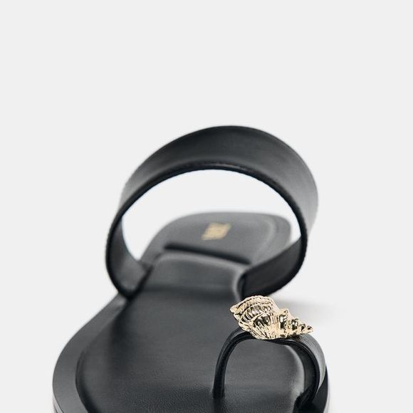 Sofisticada e atual, a sandália de R$ 249 da Zara aposta em um design fora do padrão das rasteirinhas tradicionais, com sustentação no peito do pé e dedão com acabamento de concha metálica