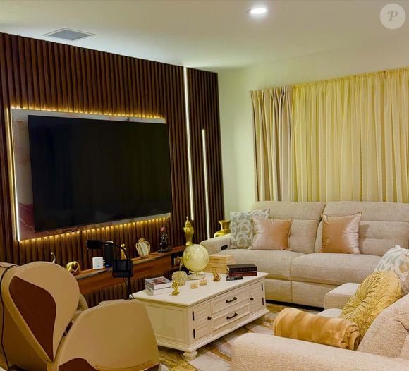 A decoração da mansão de Rick Sollo aposta em tons de bege, marrom e branco, presentes nos móveis e nos elementos decorativos. A sala de estar tem dois sofás e uma poltrona, enquanto a cozinha conta com ilha central e piso de madeira.