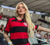 A influenciadora Karoline Lima, namorada de Leo Pereira, costuma usar sua bolsa em formato de coração de grife como espécie de 'amuleto da sorte' nos jogos.