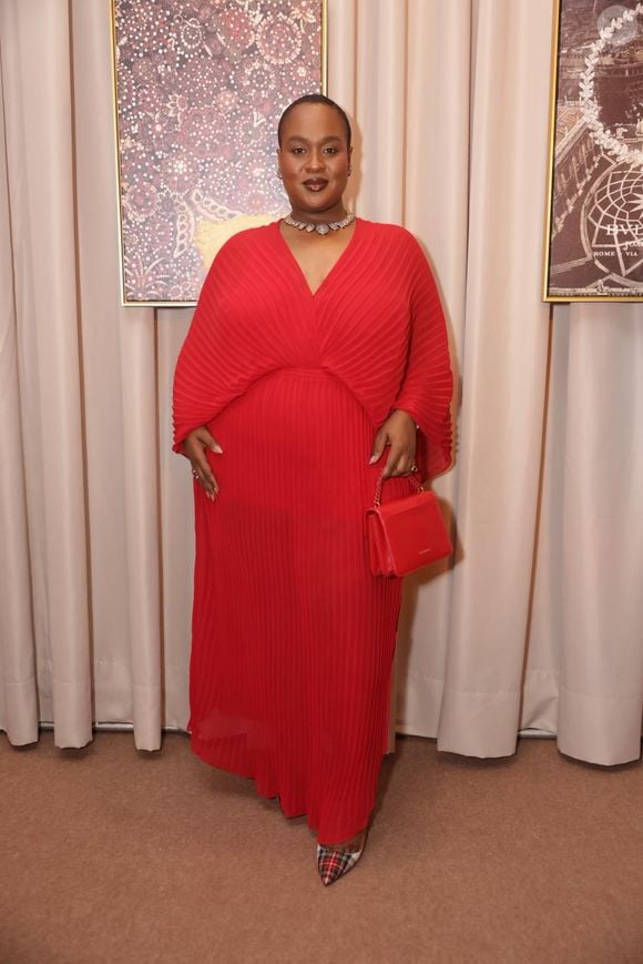 A ex-BBB Roberta Freitas faz uma impactante declaração de estilo monocromática ao eleger um vestido longo em um vibrante tom de vermelho-vivo. A peça sobressai por seu tecido inteiramente plissado e fluido, apresentando um generoso decote em V e mangas estilo capa que conferem um movimento dramático e elegante à silhueta