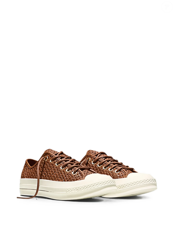 O modelo da Converse traz bico arredondado, cap toe de borracha, ilhoses metálicos, fechamento por amarração e solado flat de borracha, reunindo características clássicas em uma versão diferenciada