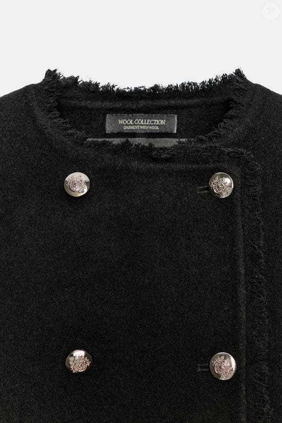 O casaco transpassado da Zara conta com acabamentos desfiados e fechamento frontal com botões metálicos, detalhes que acrescentam sofisticação à peça