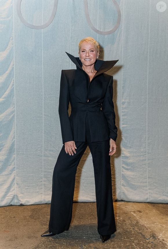 No melhor estilo 'vampira', Xuxa posou de all black no desfile da Mondepars e deixou a gola de seu blazer aberta