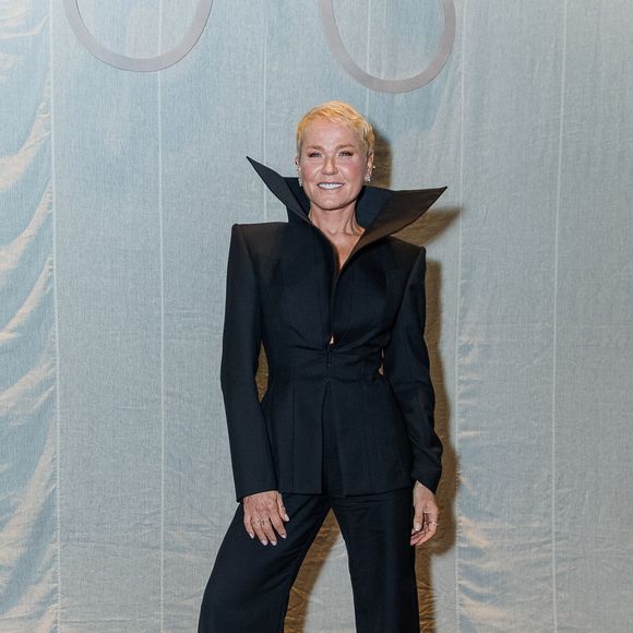 No melhor estilo 'vampira', Xuxa posou de all black no desfile da Mondepars e deixou a gola de seu blazer aberta