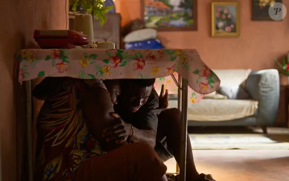 Jeff (Faíska Alves) e sua mãe, Solange, se escondem embaixo da mesa durante tiroteio na novela Dona de Mim