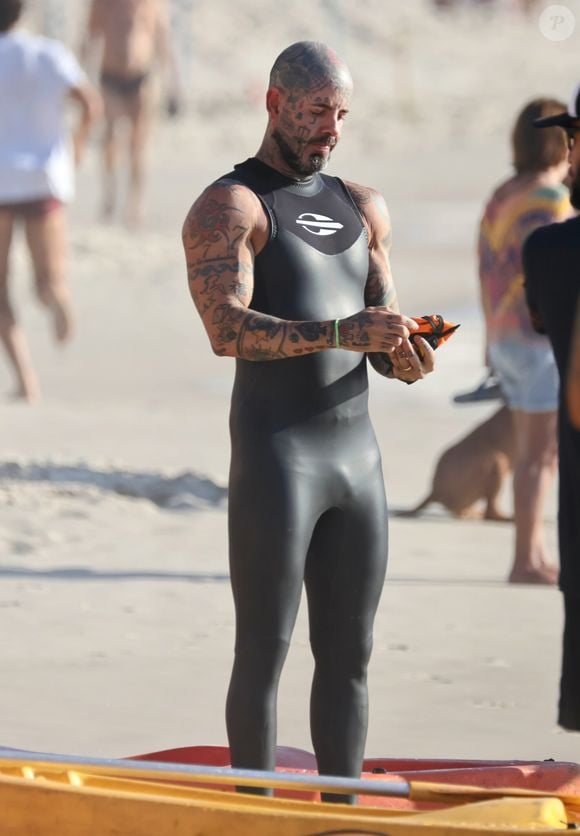 Tico Santa Cruz escolheu a praia de Copacabana para nadar e mostrou seu corpo definido em uma roupa colada