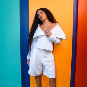 A intérprete de Maria de Fátima apostou em um look all white, composto por uma blusa estruturada de decote amplo e bermuda de alfaiataria