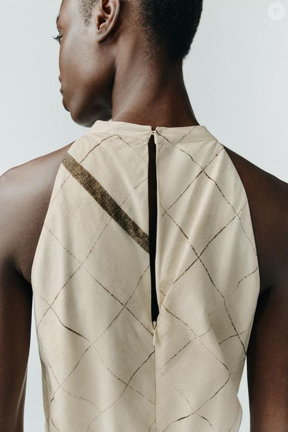 O segredo está na gola halter e na silhueta solta, com detalhe de abertura sutil que valoriza o corpo. A estampa abstrata sobre fundo branco e a barra assimétrica dão o toque moderno. Custa R$ 439,00