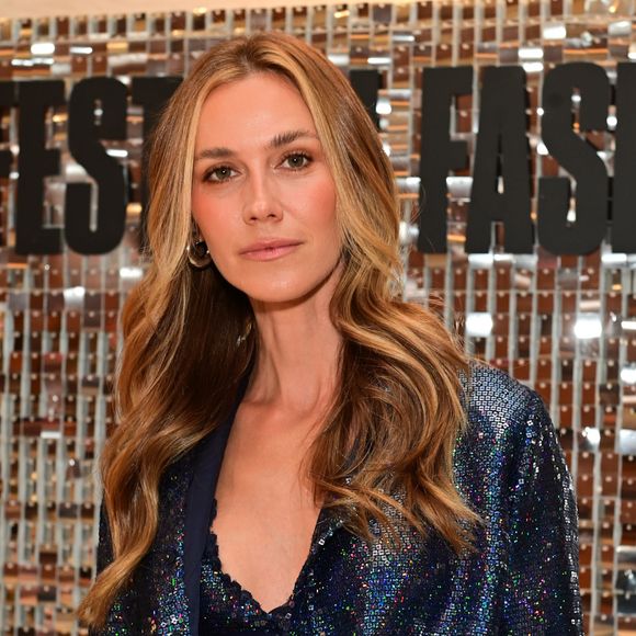 Modelo aposta em camisa com brilho azul e roxo e decote profundo com renda à mostra