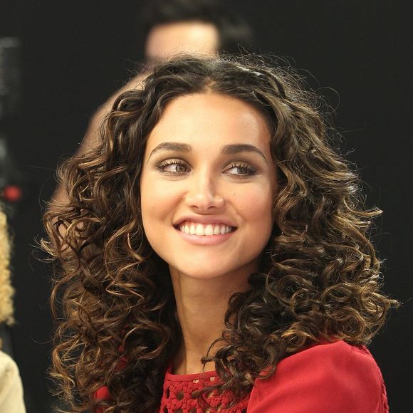 Cabelo com cachos bem definidos e risca central de Debora Nascimento reforça tendência vista nas passarelas que chega ao street style com proposta versátil