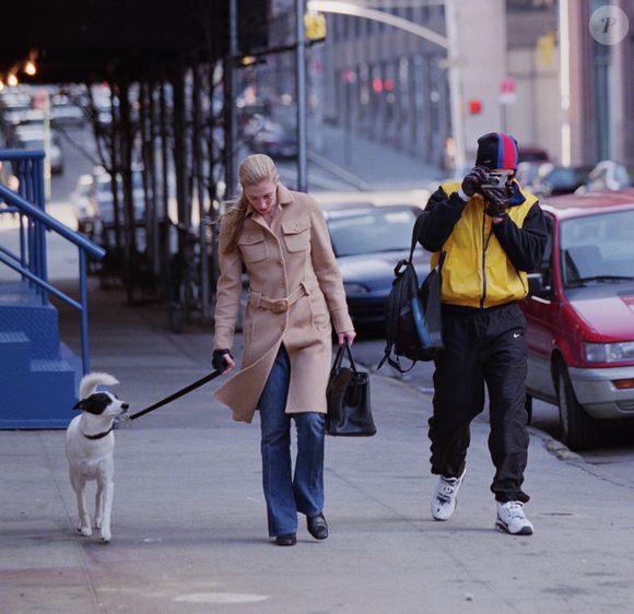Na vida real, Carolyn Bessette, esposa de John F. Kennedy Jr., foi fotografada em 1998 enquanto passeava com seu cachorro usando o icônico casaco bege da Prada, peça que se tornaria um dos símbolos mais elegantes de seu estilo minimalista dos anos 90