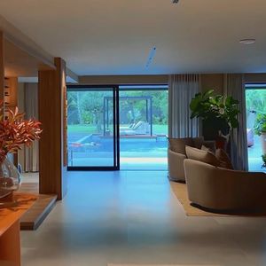 Com painéis de vidro e brises, a residência privilegia iluminação natural e integração entre os espaços internos e externos