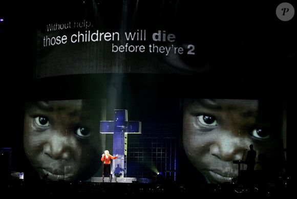 Madonna canta pendurada em uma cruz no show 'Confessions Tour' e chama atenção para a fome que afeta crianças em países da África. Veio a terceira excomunhão