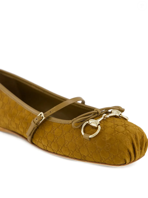 Já o detalhe metálico dourado "horsebit" no topo, acompanhado de pequenos elementos que lembram pedrarias delicadas, eleva o calçado ao status de peça-desejo