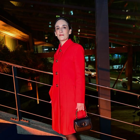 Maria Prata: a jornalista optou por um sobretudo vermelho de abotoamento duplo frontal e gola estruturada. O visual sóbrio é complementado por meia-calça escura, sapatos pretos de bico fino com detalhe metalizado no cabedal e uma bolsa de mão estruturada em couro preto com alça de bambu