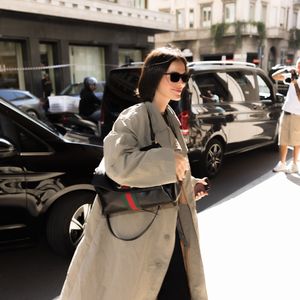 Bruna Marquezine apostou em um visual sofisticado e urbano durante sua passagem por Milão, com trench coat neutro, calça preta ampla, mocassim preto, óculos de sol e bolsa estruturada