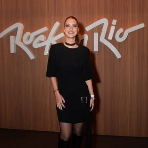 Nathalia Dill aposta em uma estética goth-chic sofisticada e minimalista. A atriz veste um vestido curto preto de mangas curtas e gola careca, enriquecido por um detalhe de fivela e faixa pendente na cintura, combinando com meia-calça fina, botas de cano alto em tom escuro e uma choker dourada rente ao pescoço