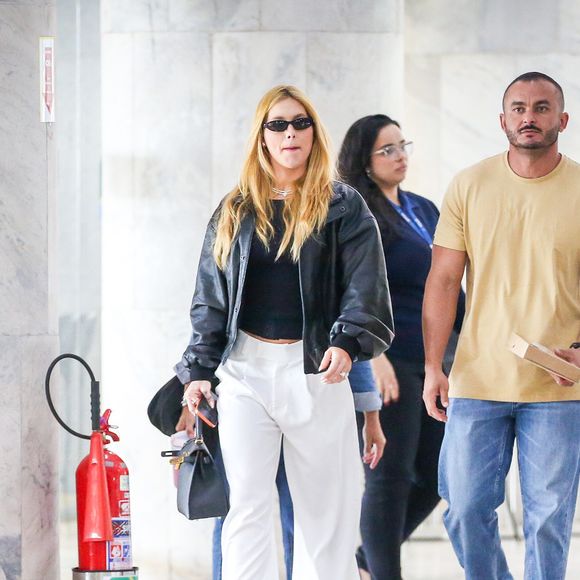 Para equilibrar a parte superior mais pesada, Virginia Fonseca apostou em uma calça branca ampla, de caimento fluido, que traz leveza e alonga a silhueta.
