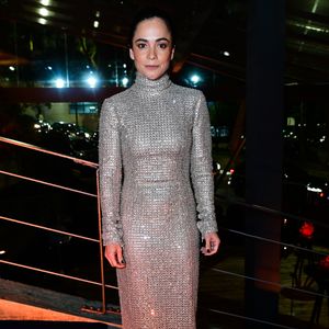 Alice Braga: a atriz apostou em um vestido longo reto inteiramente bordado com microbrilhos prateados. A peça possui gola alta e mangas longas. O penteado é um coque puxado e alinhado, acompanhado de maquiagem suave e unhas pintadas de escuro