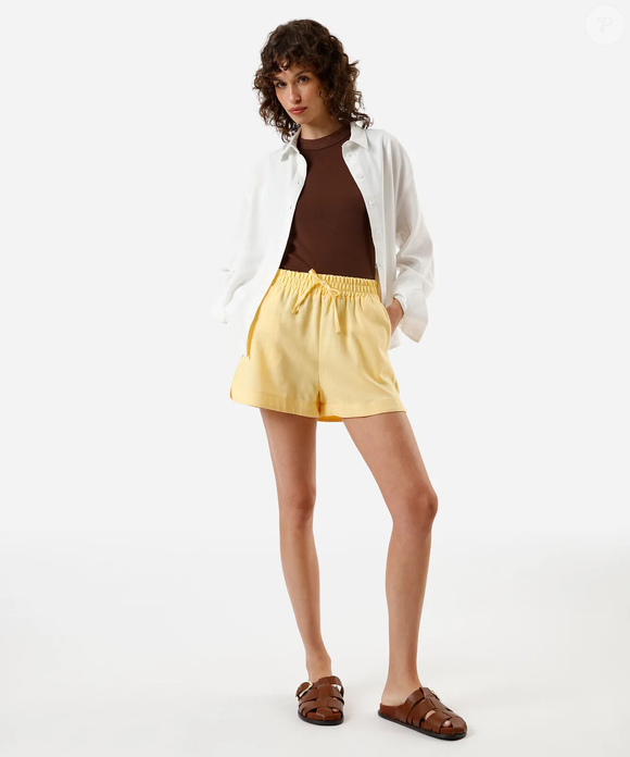 O short de linho amarelo da C&A, por R$ 119,99, traz uma dose de cor ao visual e cria um contraste interessante com o acabamento em denim do Adidas Tokyo Jeans