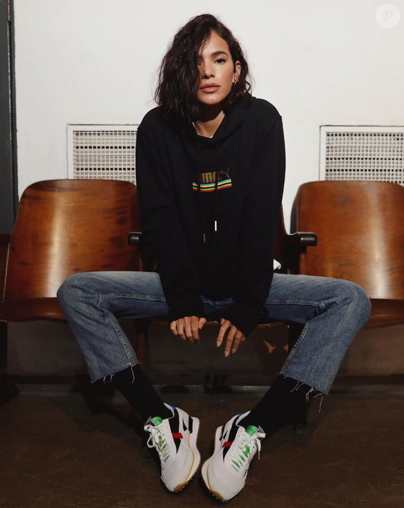 Bruna Marquezine é fã de tênis: atriz usa calça jeans com calçado branco estampado de solado mais alto, além de meia e moletom pretos. O look é perfeito para a transição entre o outono e o inverno.