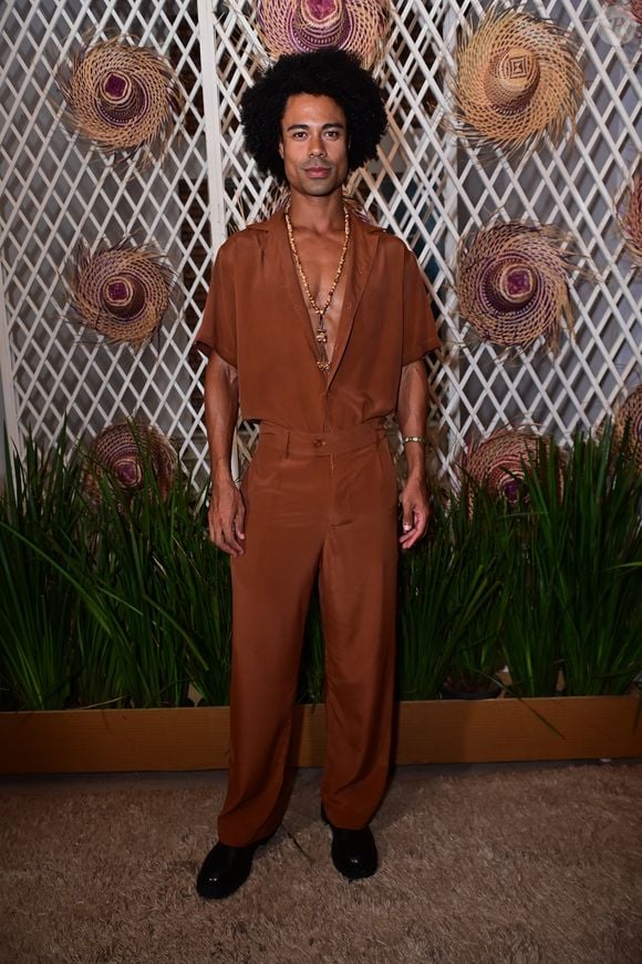Breno investiu no utilitarismo elegante com um conjunto monocromático de alfaiataria em tom marrom-terroso, composto por camisa de mangas curtas usada entreaberta e calça de corte reto. O look de pegada naturalista foi complementado por um maxicolar de contas e sapatos pretos