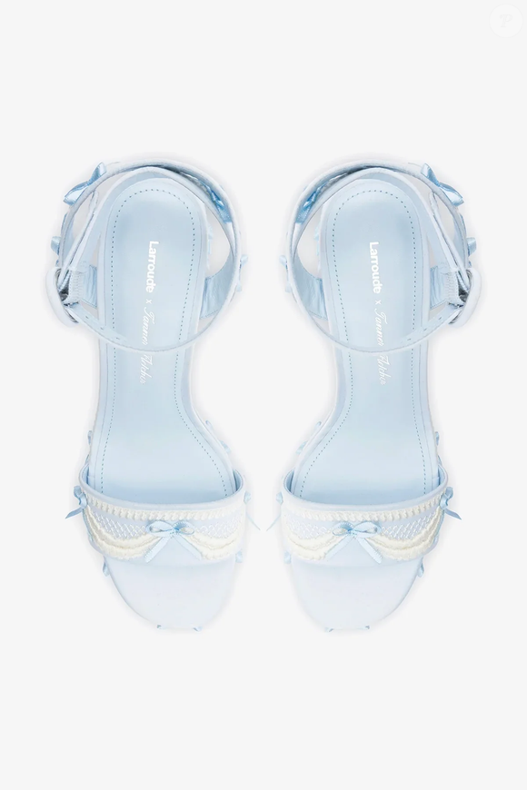 Até o fechamento desta matéria, a Larroudé x Tanner Fletcher: Sandália Dolly Cake & Lace Cetim Azul estava disponível por R$ 2.390. A criação reforça o encontro entre a tendência coquette, a inspiração em Maria Antonieta e o universo bridal em uma única peça