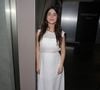 Maria Clara Senra usou um vestido branco longo, com transparência discreta na parte superior e sandálias claras