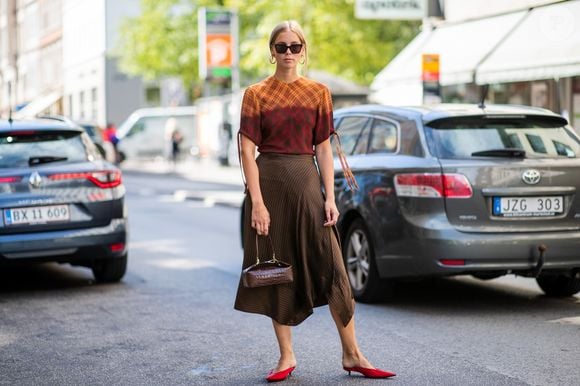 A saia midi com mule marrom é uma combinação para quem busca um visual casual com um toque de elegância. O modelo da Moleca, com acabamento que remete à camurça, pode complementar a produção sem recorrer aos saltos