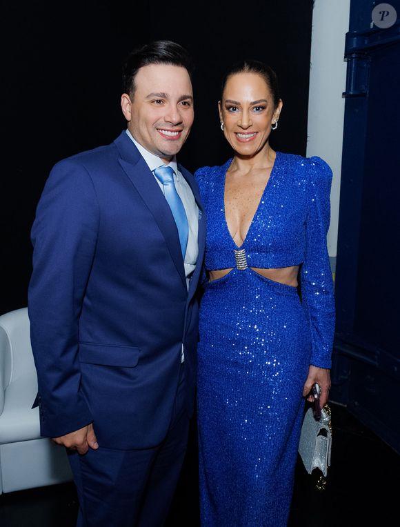 O casal combinou na palheta mas Silvia Abravanel escolheu vestido de paetê azul com recortes laterais na altura do abdômen e uma bolsa prata brilhosa para 55ª edição do Troféu Imprensa após a morte do seu pai Silvio Santos