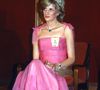 Foto mostra Princesa Diana com vestido longo na cor rosa acetinado, com alças de amarrações. Um modelo com verdadeira aura de princesa fashionista.