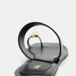 A Zara apresenta sua nova rasteirinha de R$ 249 com proposta nada convencional: estrutura que valoriza o peito do pé e o dedão, além do detalhe de concha metálica que elevam o visual