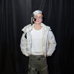Juliano Floss ousou na escolha do look para prestigiar o evento fashion em São Paulo. Além da jaqueta puffer estampada e da calça jeans cargo de modelagem ampla, o influenciador deixou à mostra uma cueca branca de renda, criando um detalhe provocante na produção