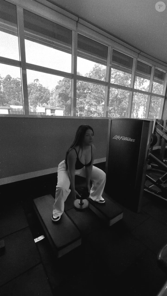 Simaria optou por um look fitness de top preto ajustado com alças finas e calça de moletom clara e larga de cintura alta