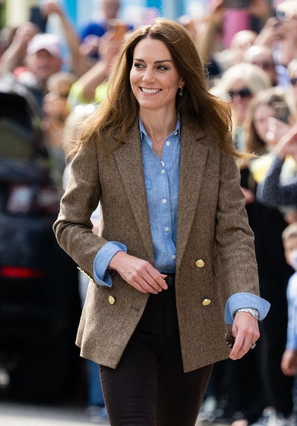 Durante viagem à Escócia, Kate Middleton estava usando uma camisa azul, além de blazer e calça.